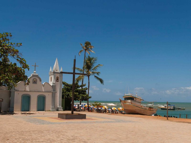 igreja na Praia do Forte, com o mar e algumas embarcações