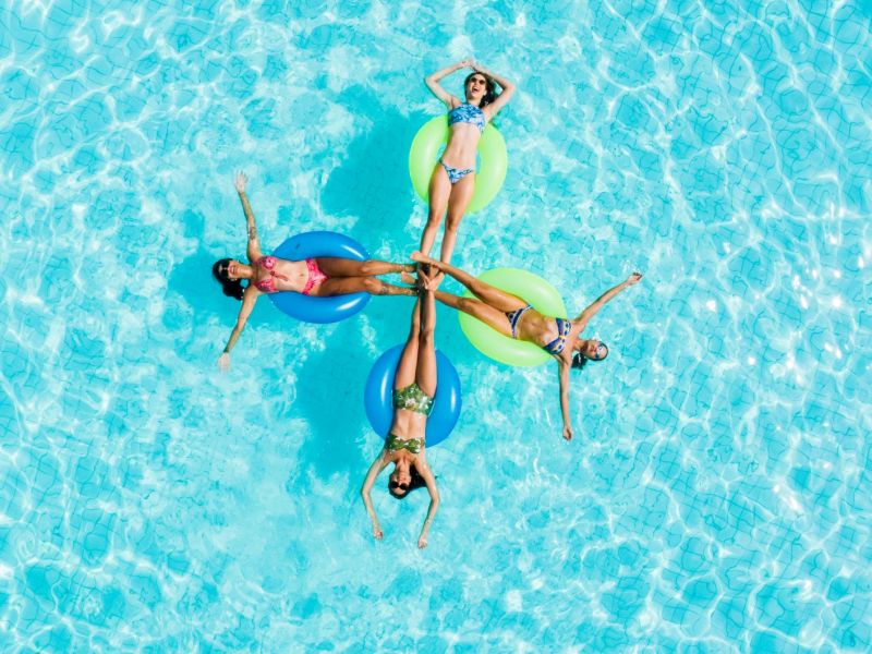 Imagem de um grupo de pessoas boiando na piscina