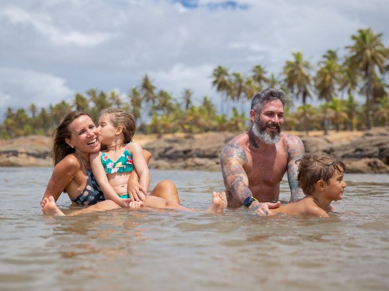 Imagem de dois adultos e duas crianças se divertindo em piscinas naturais