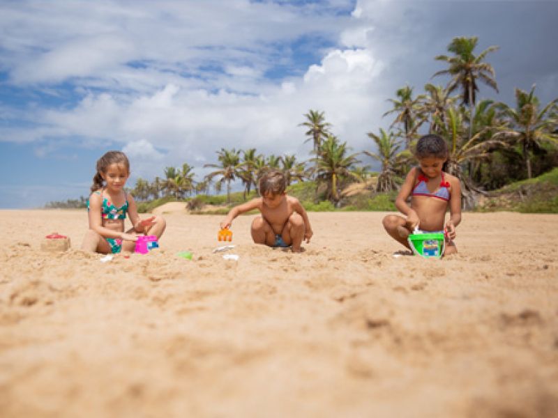 Imagem de crianças brincando na areia da praia