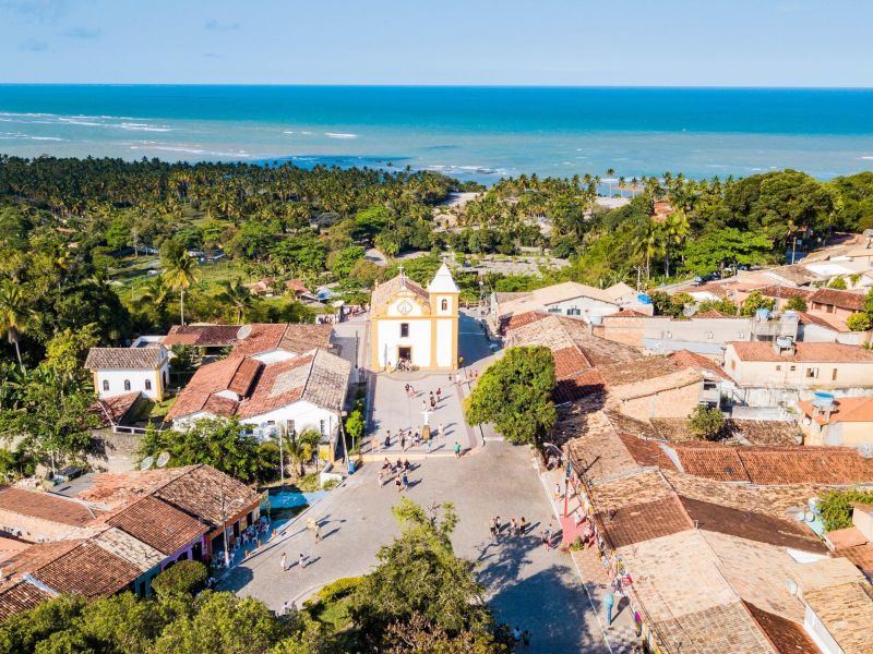 Igreja no centro da cidade em Arraial D'Ajuda, com o mar ao fundo