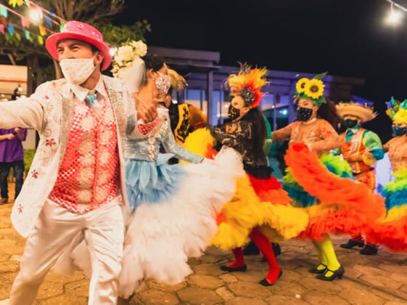 Imagem de um grupo de pessoas vestidos com roupas típicas de Festa Junina para dançar quadrilha.