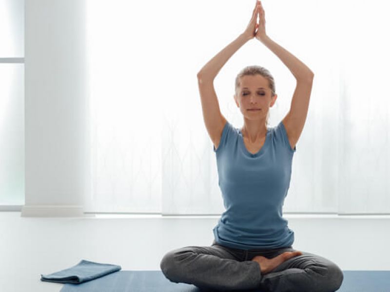 Imagem de uma mulher aprendendo como praticar yoga