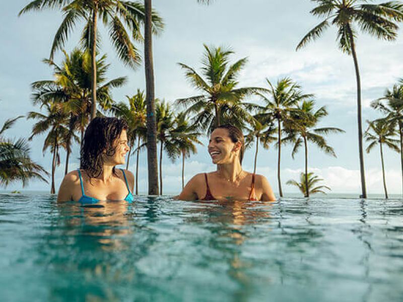 Imagem de duas mulheres conversando em uma piscina