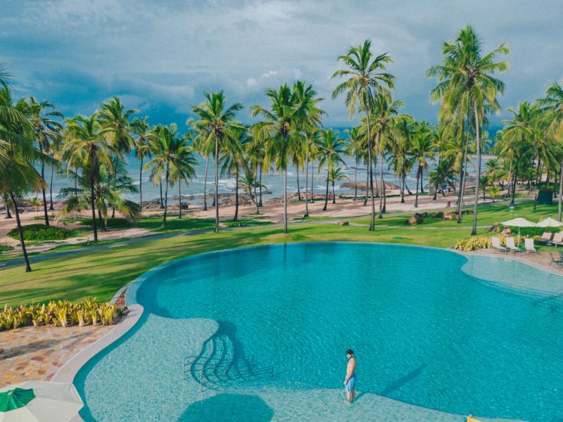 Piscinas do Costa do Sauípe Resorts com coqueiros o mar da Bahia ao fundo