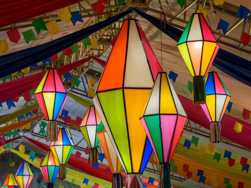 Balões e bandeirinhas coloridas de festa junina, ficadas no teto de um salão