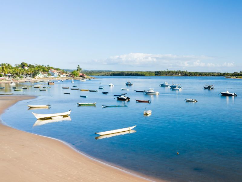 Orla da praia em Itacaré, com diversos pequenos barcos de pesca ancorados