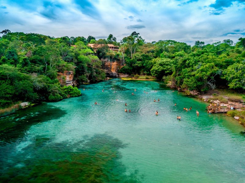 piscina natural cristalina cercado de vegetação natival com algumas pessoas nadando na Chapada Diamantina, Bahia