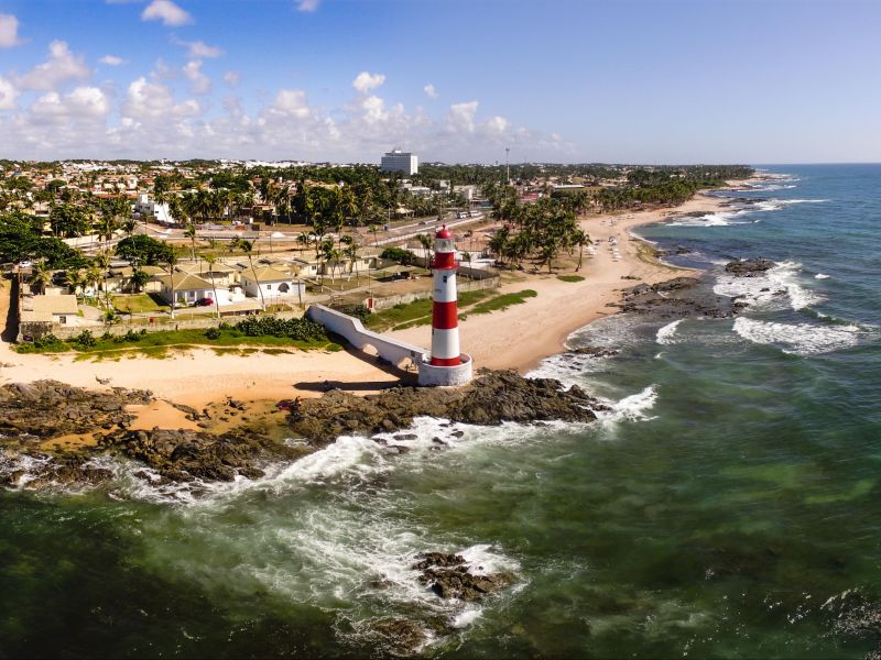 Praia de Itapuã com o farol no centro e ambos os lados da praia se estendendo até o horizonte