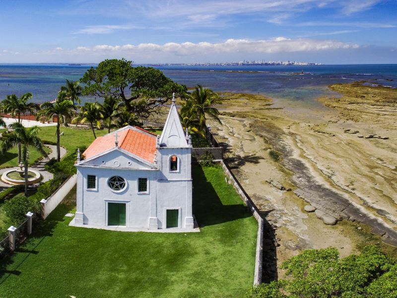 Igreja branca com o mar ao fundo