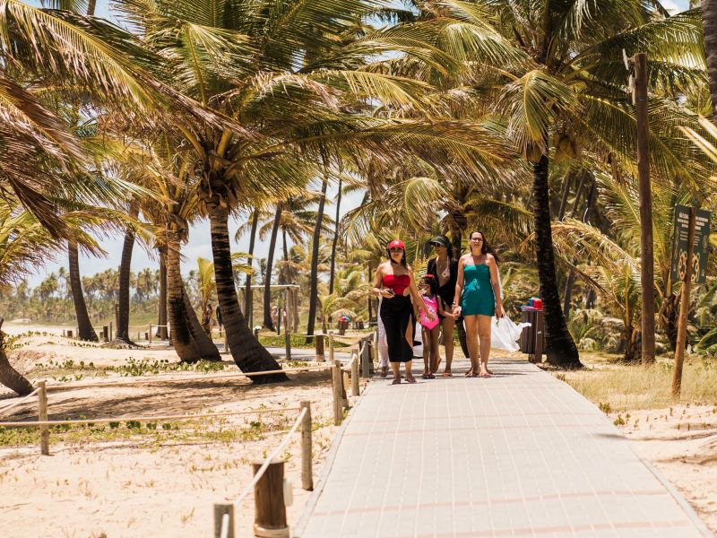 Pessoas caminhando pela passarela que leva para a praia em Costa do Sauípe