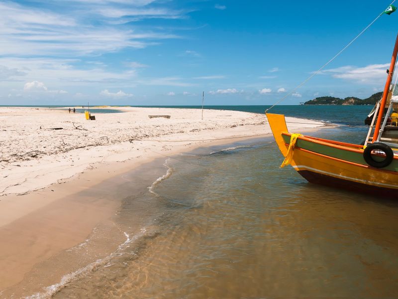 Parte de um barco de pesca proximo à areia da praia na Baía de Camamu