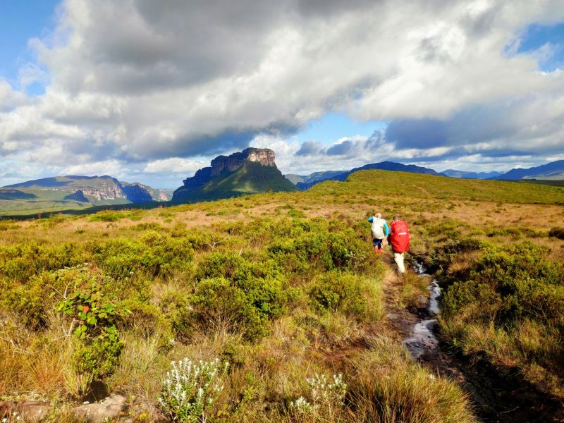 Duas pessoas caminhando por uma trilha em meio à Chapada Diamantina