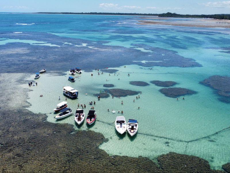 Vista de cima de barcos ancorados nas piscinas naturais formadas no mar do Morro de São Paulo