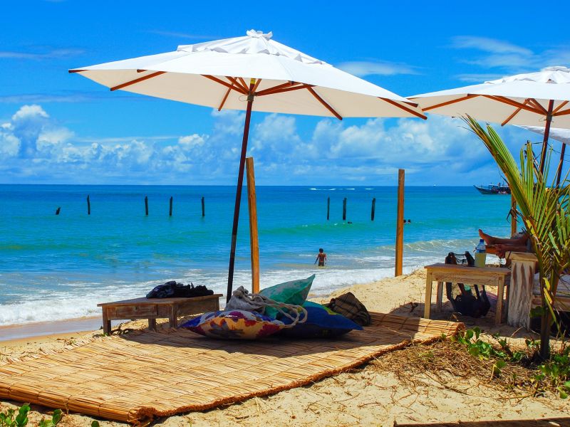 Dois guarda-sóis abertos em frente à Praia de Porto Seguro